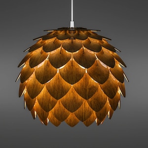 Pode incluir: Uma moderna lumin&aacute;ria pendente com um design de madeira em camadas. A luz tem a forma de um globo, com pe&ccedil;as de madeira sobrepostas criando uma superf&iacute;cie texturizada. A luz quente brilha atrav&eacute;s das lacunas, criando um ambiente acolhedor. A lumin&aacute;ria pende de um cabo branco.