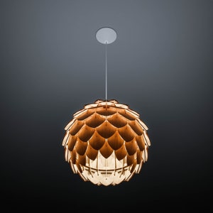 Pode incluir: Uma lumin&aacute;ria pendente com uma c&uacute;pula esf&eacute;rica feita de pe&ccedil;as de madeira sobrepostas. A luz tem um tom de madeira quente e natural e pende de uma placa de teto branca por um fino cabo branco. O fundo &eacute; um gradiente de cinza escuro.