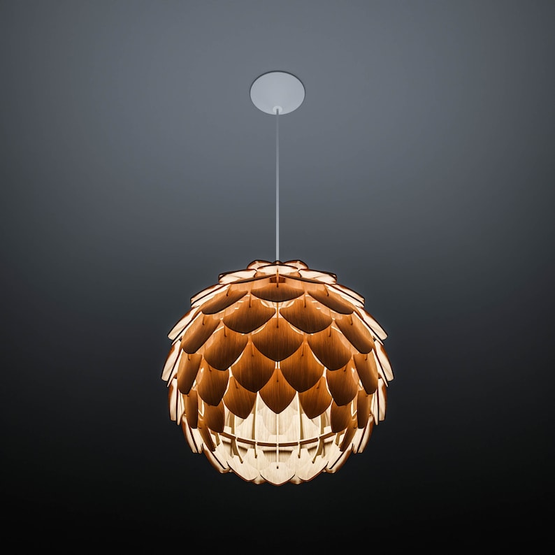 Pode incluir: Uma lumin&aacute;ria pendente com uma c&uacute;pula esf&eacute;rica feita de pe&ccedil;as de madeira sobrepostas. A luz tem um tom de madeira quente e natural e pende de uma placa de teto branca por um fino cabo branco. O fundo &eacute; um gradiente de cinza escuro.