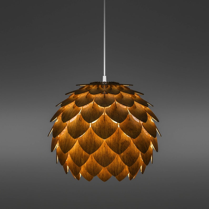 Pode incluir: Uma moderna lumin&aacute;ria pendente com um design de madeira em camadas. A luz tem a forma de um globo, com pe&ccedil;as de madeira sobrepostas criando uma superf&iacute;cie texturizada. A luz quente brilha atrav&eacute;s das lacunas, criando um ambiente acolhedor. A lumin&aacute;ria pende de um cabo branco.