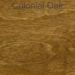 Pode incluir: Close-up de um padr&atilde;o de gr&atilde;o de madeira com um tom castanho-dourado quente. O texto "Colonial Oak" &eacute; exibido no topo. O gr&atilde;o da madeira apresenta um design natural e fluido, mostrando a textura e as varia&ccedil;&otilde;es de cor.