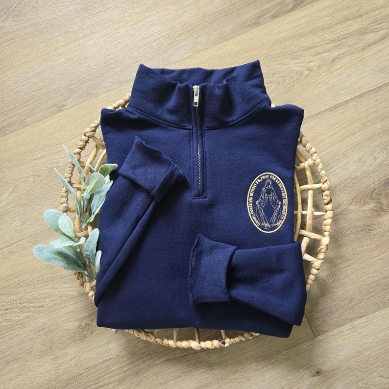 A navy sweatshirt with vegas gold thread for the miraculous medal.