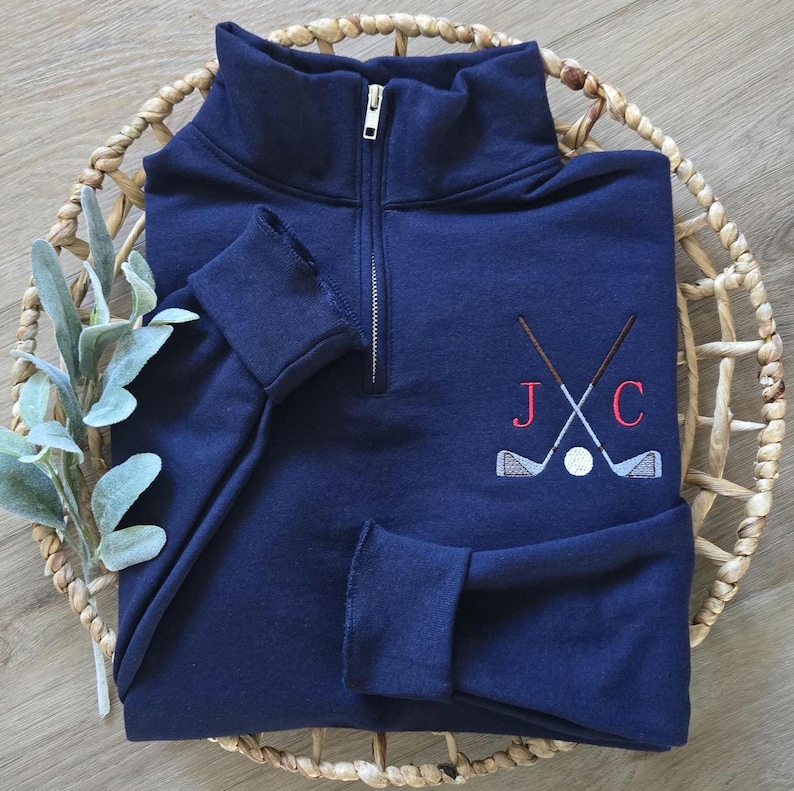 A navy quarter zip with red thread for the initials.