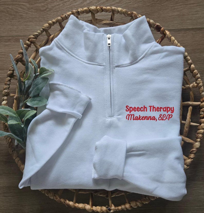 Pu&ograve; includere: Felpa bianca con zip a un quarto con testo ricamato in rosso che recita "Speech Therapy Makenna, SLP".