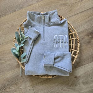 An oxford sweatshirt with white thread for OTA and army green thread for the name.