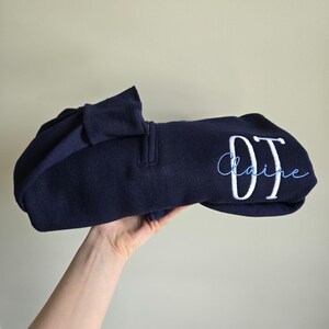 A navy sweatshirt with white thread for OT and sky blue for the name.