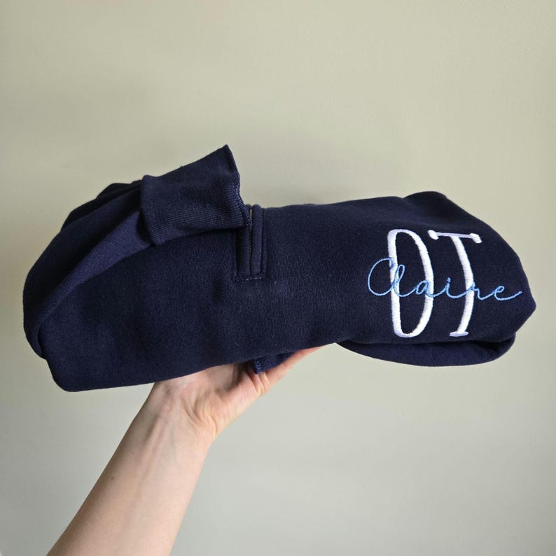 A navy sweatshirt with white thread for OT and sky blue for the name.