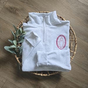An ash sweatshirt with fushia thread.