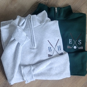 An ash quarter zip with sky blue for the initials, and a forest green with light grey for the initals.