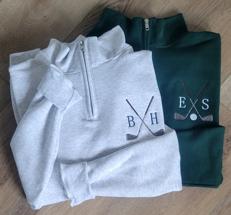 An ash quarter zip with sky blue for the initials, and a forest green with light grey for the initals.