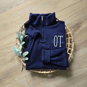 A navy sweatshirt with white thread for OT and sky blue for the name.