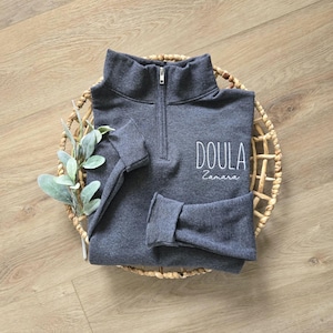 A black heather quarter zip with white thread.