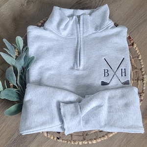 An ash sweatshirt with navy blue thread for the initials.