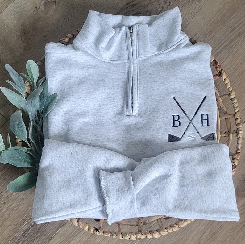 An ash sweatshirt with navy blue thread for the initials.