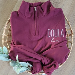 A maroon sweatshirt with white thread.