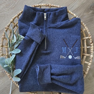 A vintage heather navy quarter zip with sky blue thread for the initials.