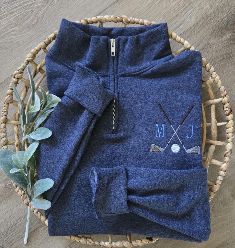 A vintage heather navy quarter zip with sky blue thread for the initials.