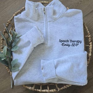An ash quarter zip with black thread.