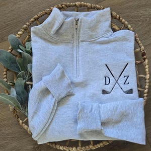 An ash sweatshirt with navy blue thread for the initials.