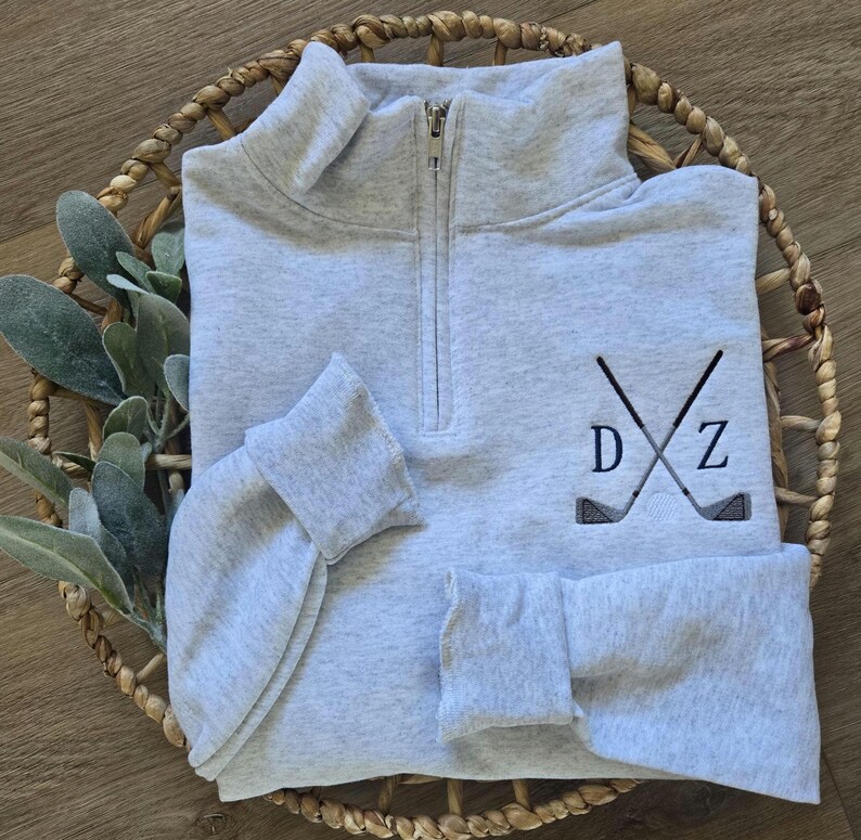 An ash sweatshirt with navy blue thread for the initials.