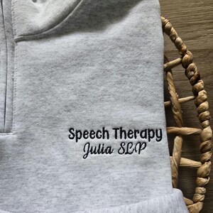 An ash quarter zip with black thread.