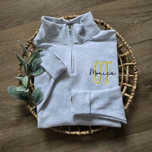 An ash sweatshirt with yellow and navy thread.