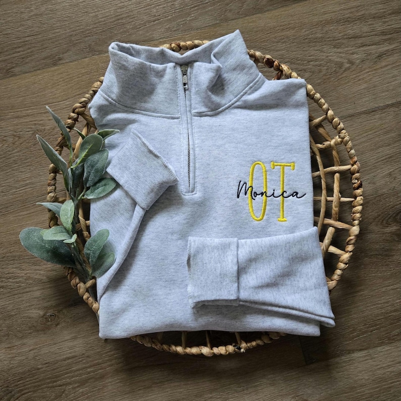 An ash sweatshirt with yellow and navy thread.