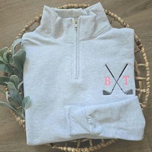 An ash sweatshirt with neon pink thread for the initials