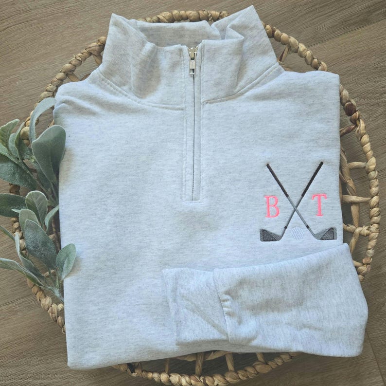An ash sweatshirt with neon pink thread for the initials