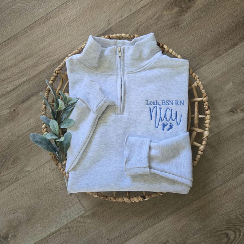 An ash grey sweatshirt with sky blue thread.