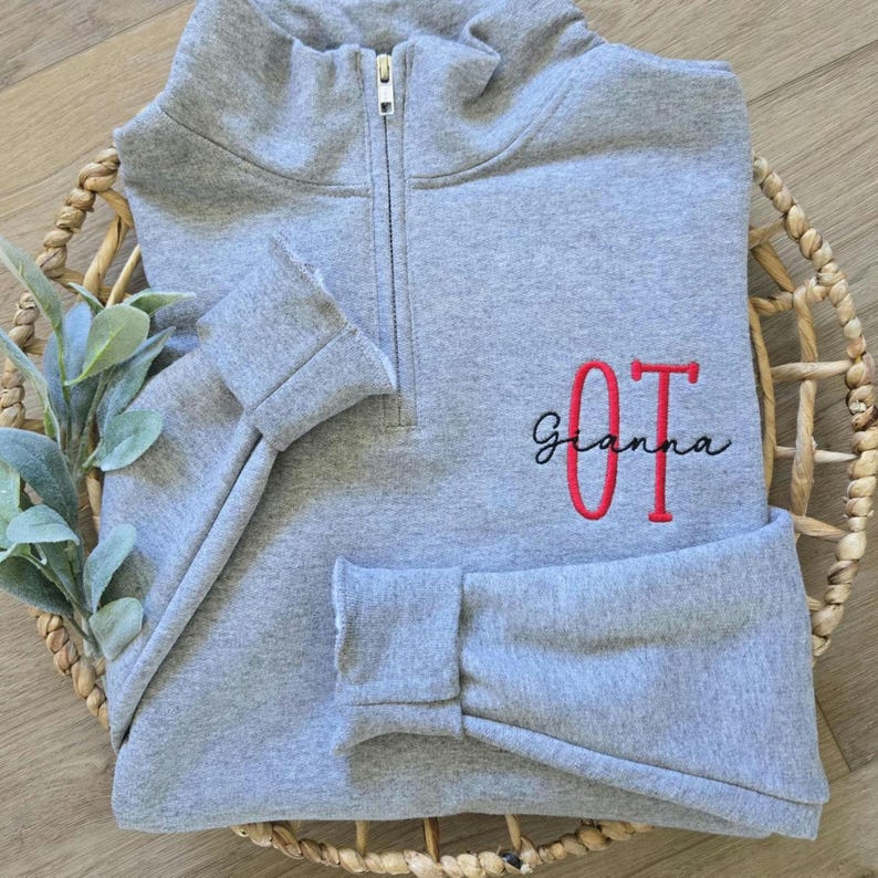 An oxford sweatshirt with red thread for OT and black thread for the name.