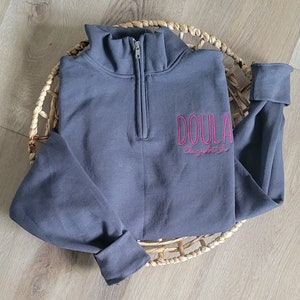 A charcoal sweatshirt with fuschia thread.