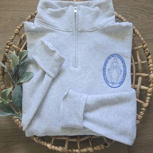 An ash sweatshirt with sky blue thread.