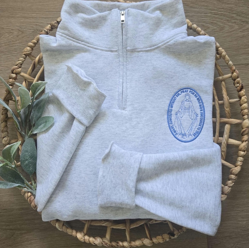 An ash sweatshirt with sky blue thread.