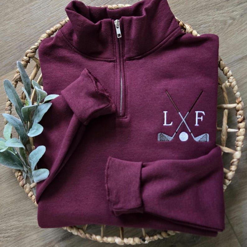 A maroon quarter zip with white thread for the initials.