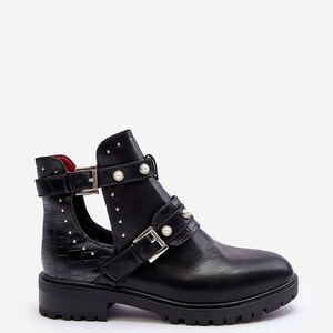 May include: Black ankle boot with a cut-out design, featuring multiple straps with silver buckles and faux pearl accents. The boot has a textured, crocodile-like pattern on the side and a lug sole.