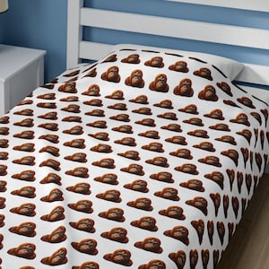 May include: A white twin-sized bedspread with a repeating pattern of orangutan faces. The bedspread is made of a soft, comfortable fabric and is perfect for adding a touch of whimsy to any bedroom.