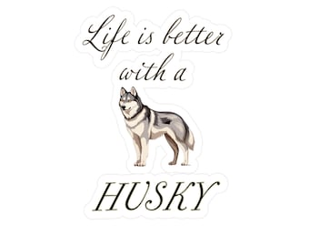 May include: A die-cut sticker featuring a gray and white Siberian Husky standing in profile. Above the dog, the text reads Life is better with a, and below the dog, the word HUSKY is printed in a black, elegant, cursive-style font.