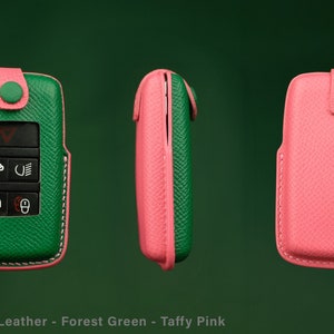 May include: A green and pink leather key fob with a textured finish. The fob has a key chain loop and a button on the top. The text "Lecozzy Artisans" is visible in the upper right corner of the image.