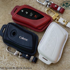 Puede incluir: Tres fundas de cuero para llaves de coche. Las fundas son de color negro, rojo y blanco. La funda negra tiene la palabra "Collette" grabada en relieve. La funda roja tiene un botón con la palabra "Hold" en ella. La funda blanca tiene un diseño en relieve sutil.