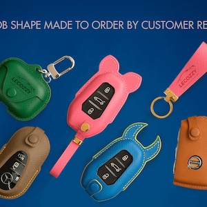 May include: Five different key fob covers made of leather in various colors and shapes. The covers are designed to fit different car key fobs. The covers are all made by the company Lecozzy Artisans.