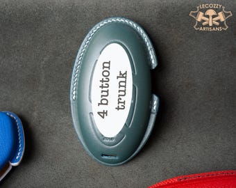 May include: A dark blue leather key fob with a white oval label that says "4 button trunk".