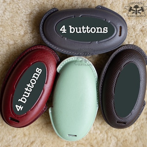 Puede incluir: Cuatro llaveros de cuero con el texto "4 buttons" en cada uno. Los llaveros son de diferentes colores: gris oscuro, rojo, verde claro y marrón.