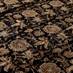 May include: Black fabric with a gold floral pattern. The fabric has a textured, woven look.