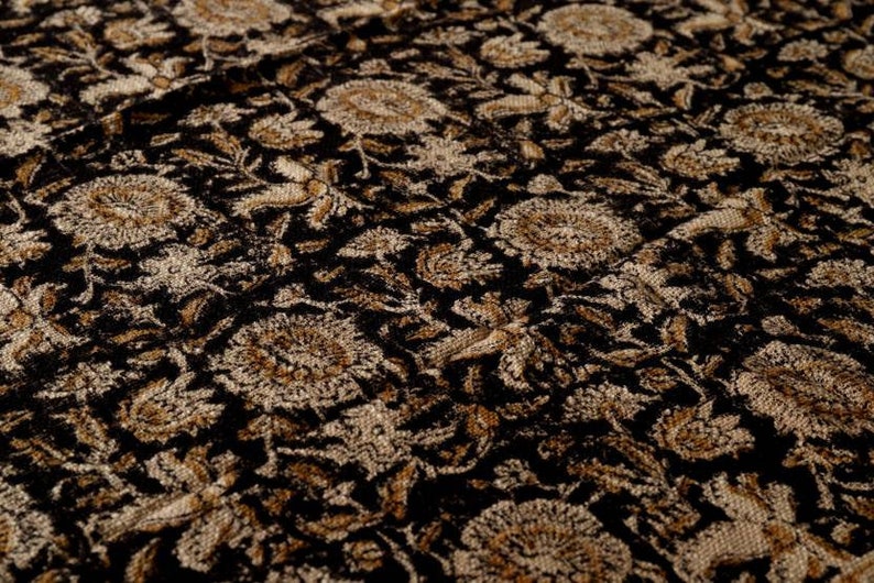 May include: Black fabric with a gold floral pattern. The fabric has a textured, woven look.