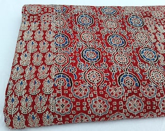 Op de afbeelding: Rode kantha-deken met een bloemenpatroon in wit en blauw. De deken is gemaakt van katoen en met de hand gestikt.