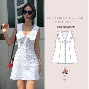 May include: A white mini dress with a large butterfly collar and a button-up front. The dress has a fitted bodice and a flared skirt. The sewing pattern is for a butterfly collar mini dress.