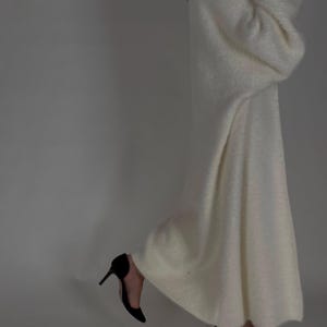 Op de afbeelding: Een witte, pluche cardigan met lange mouwen, een losse pasvorm en een lange zoom.