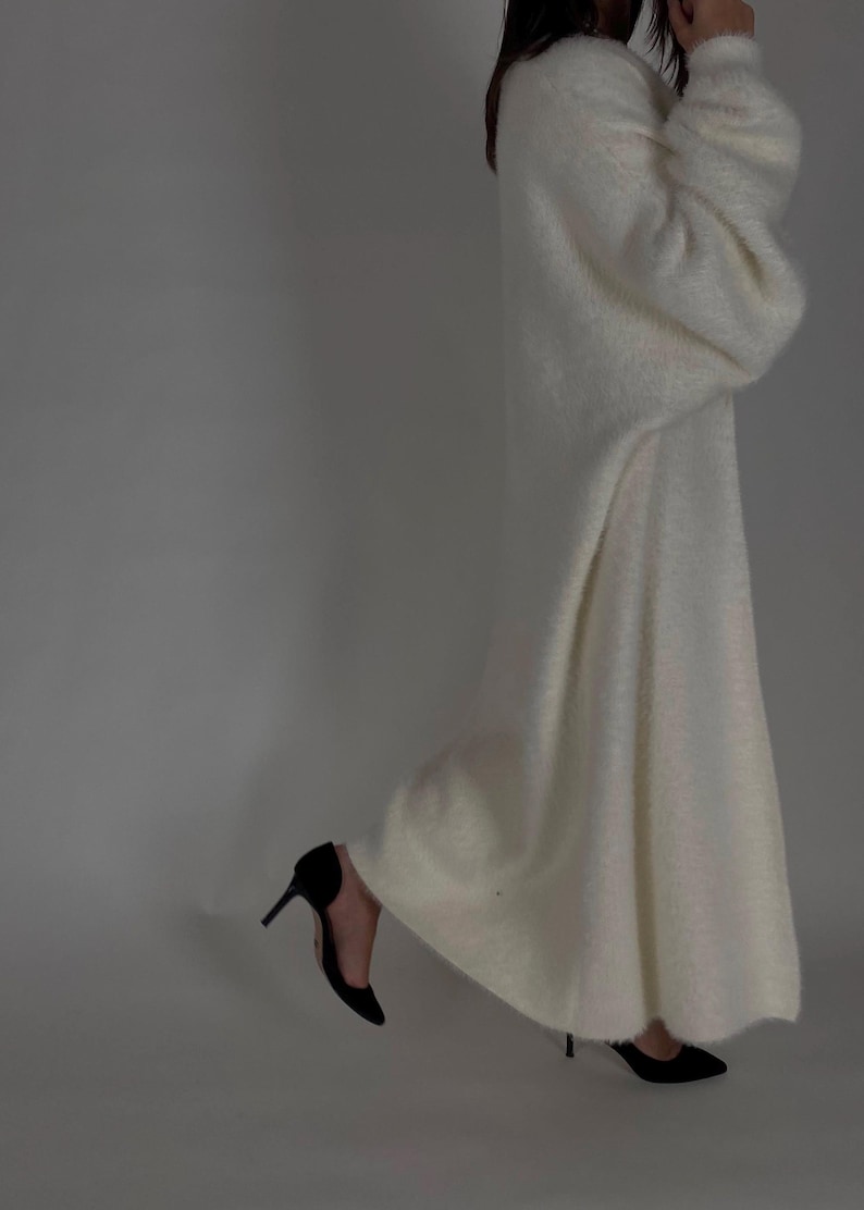 Op de afbeelding: Een witte, pluche cardigan met lange mouwen, een losse pasvorm en een lange zoom.