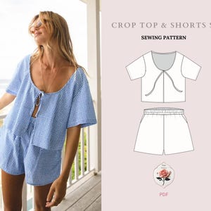 以下が含まれることがあります： クロップトップとショートパンツのセットの縫製パターン。パターンはピンクの背景に線画で示されています。画像の上部に「Crop Top & Shorts Set Sewing Pattern」というテキストがあります。画像の下部に「PDF」というテキストがあります。